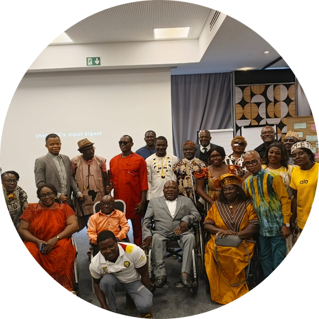 A large gathering of CAMAB Women members and partners in a conference room, several using wheelchairs and white canes.