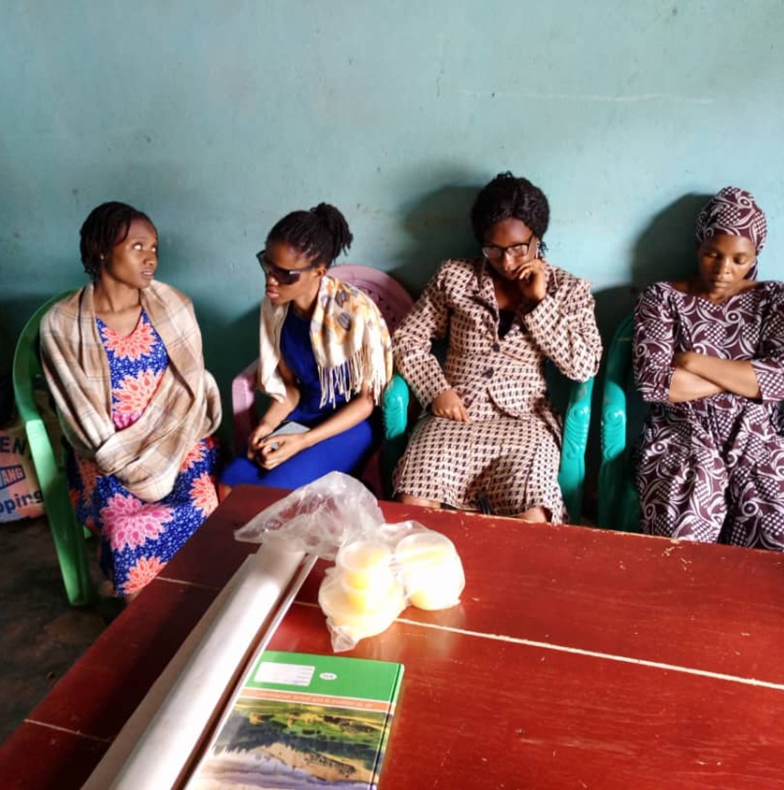 Four CAMAB Women members seated in a row, one holding a white cane.