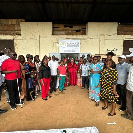 A crowd gathered outside the building at the opening of the CAMAB Centre, beneath a CAMAB banner.