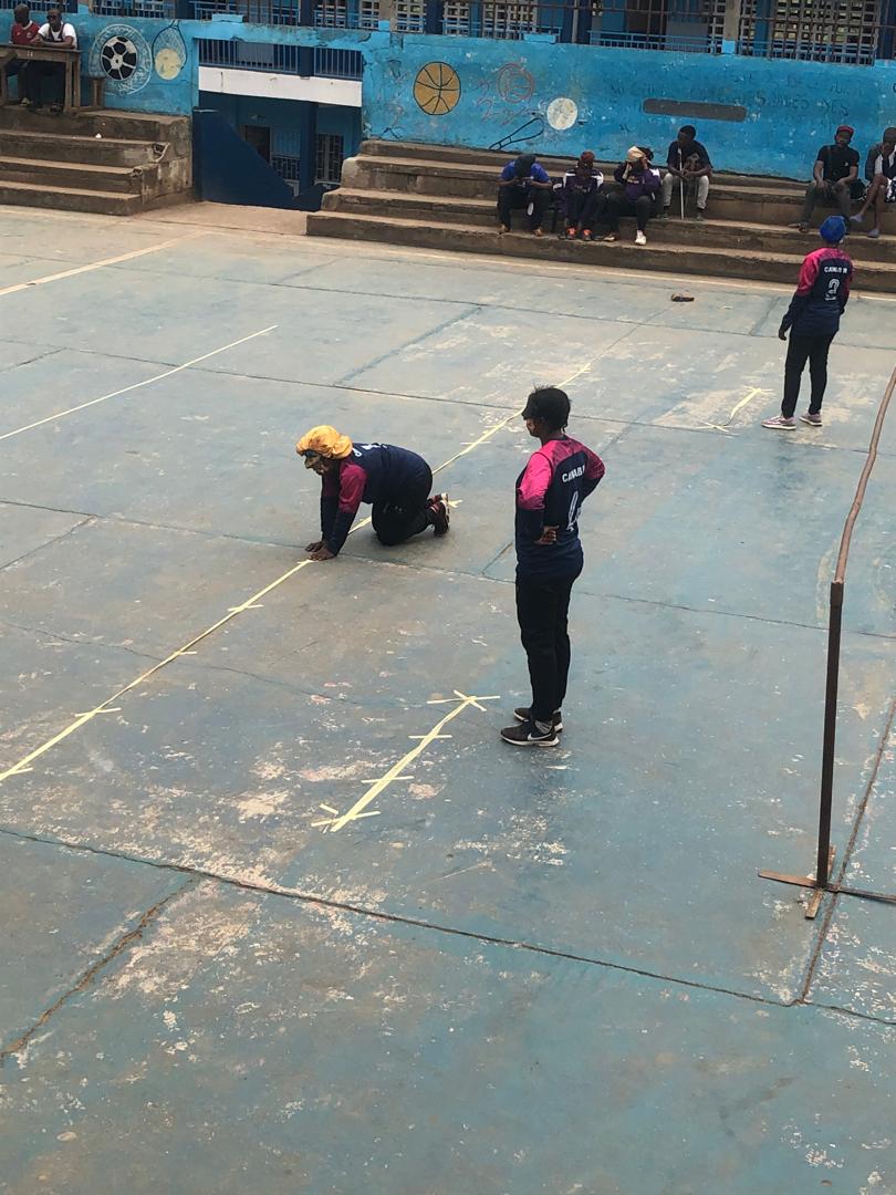 Outdoor sports court seen from above, two players on the marked surface - a blind sport session.