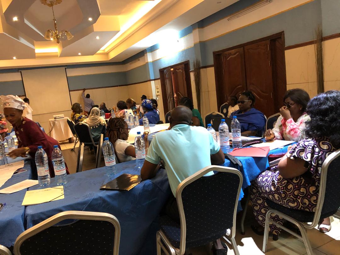 Hotel conference room; participants seated at round tables under a chandelier.