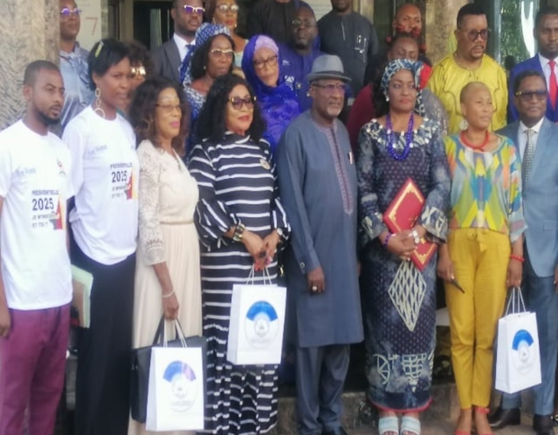 Participants at a CAMAB Women event holding branded bags, some wearing event shirts marked 2025.