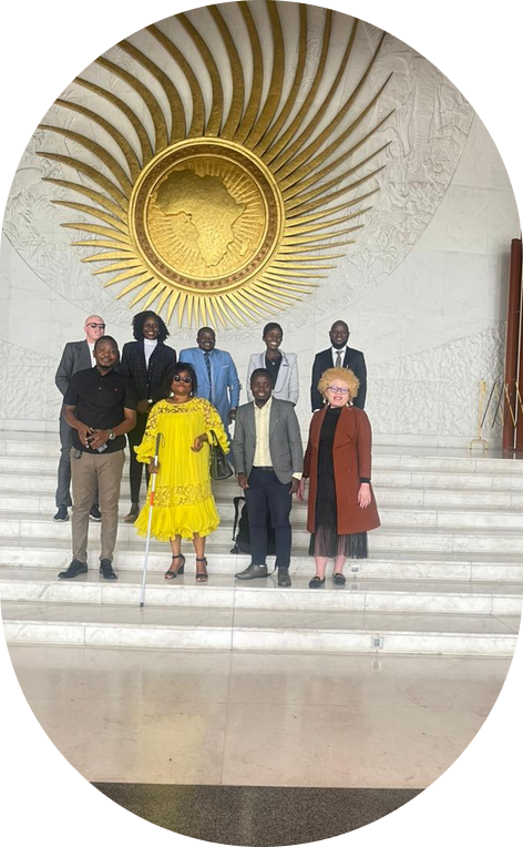 A CAMAB Women delegation on the steps of the African Union plenary hall, a member with a white cane at the front.